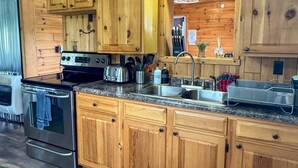 A kitchen with wooden cabinets, stainless steel appliances, and a granite countertop.