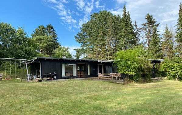 A modern cabin with a large deck, surrounded by dense forest. - 4 bedroom beautiful home in Vejby (Vejby)