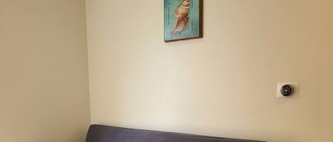 Un sofá gris en una habitación con paredes beige y suelo de baldosas.