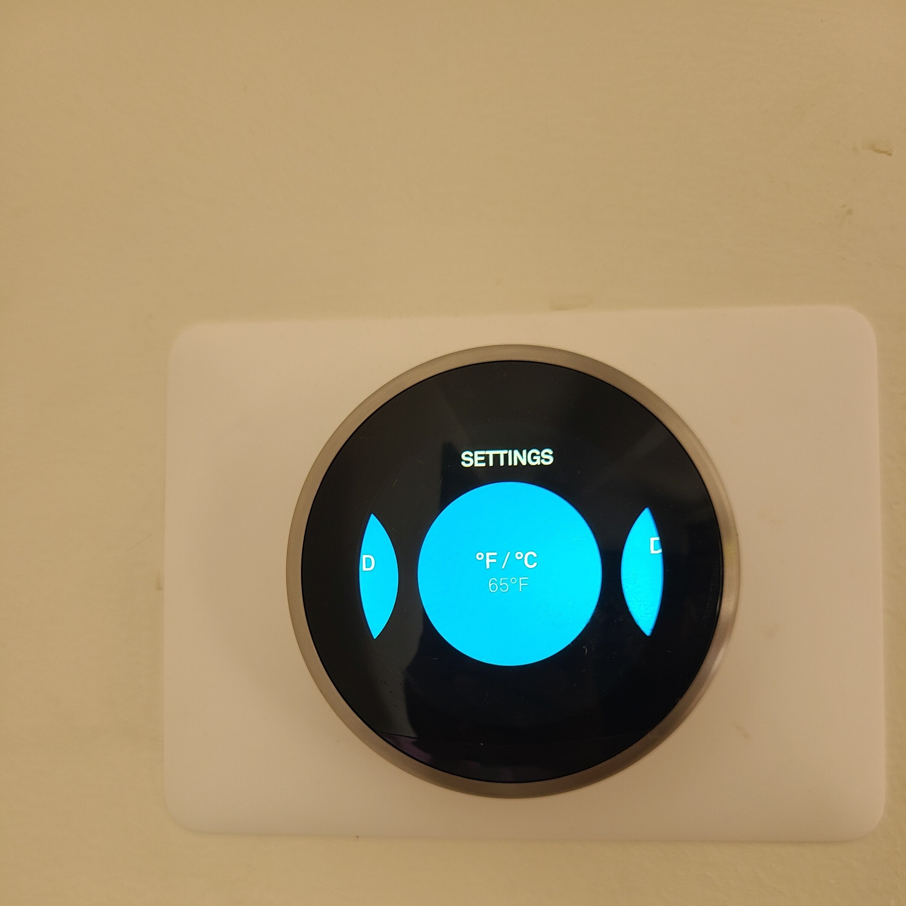 A circular control panel with a settings menu and temperature display.