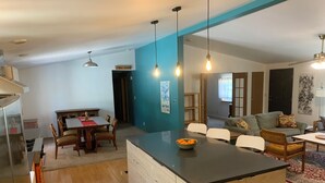 A modern kitchen with a central island, wooden cabinets, and a dining area with a table and chairs. - Spacious 4 bd 2 bth Ridgway-Ouray Ranch Home; Adventure Basecamp! STR-1-2024-069 (Ridgway)