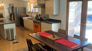 A modern kitchen with a central island, stainless steel appliances, and a dining area with a wooden table and chairs. - Spacious 4 bd 2 bth Ridgway-Ouray Ranch Home; Adventure Basecamp! STR-1-2024-069 (Ridgway)