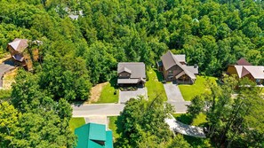A residential area with multiple houses surrounded by dense greenery.