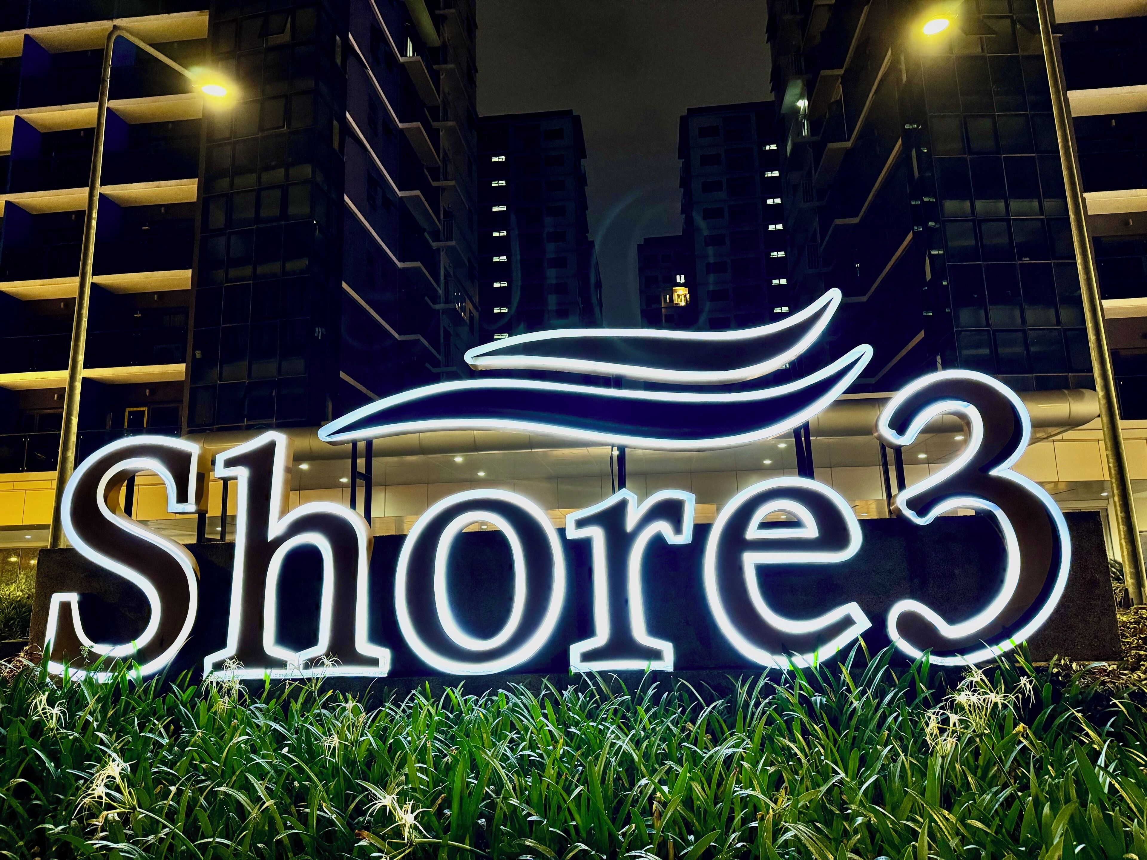 A neon sign with the text "Shore3" and a stylized wave design.