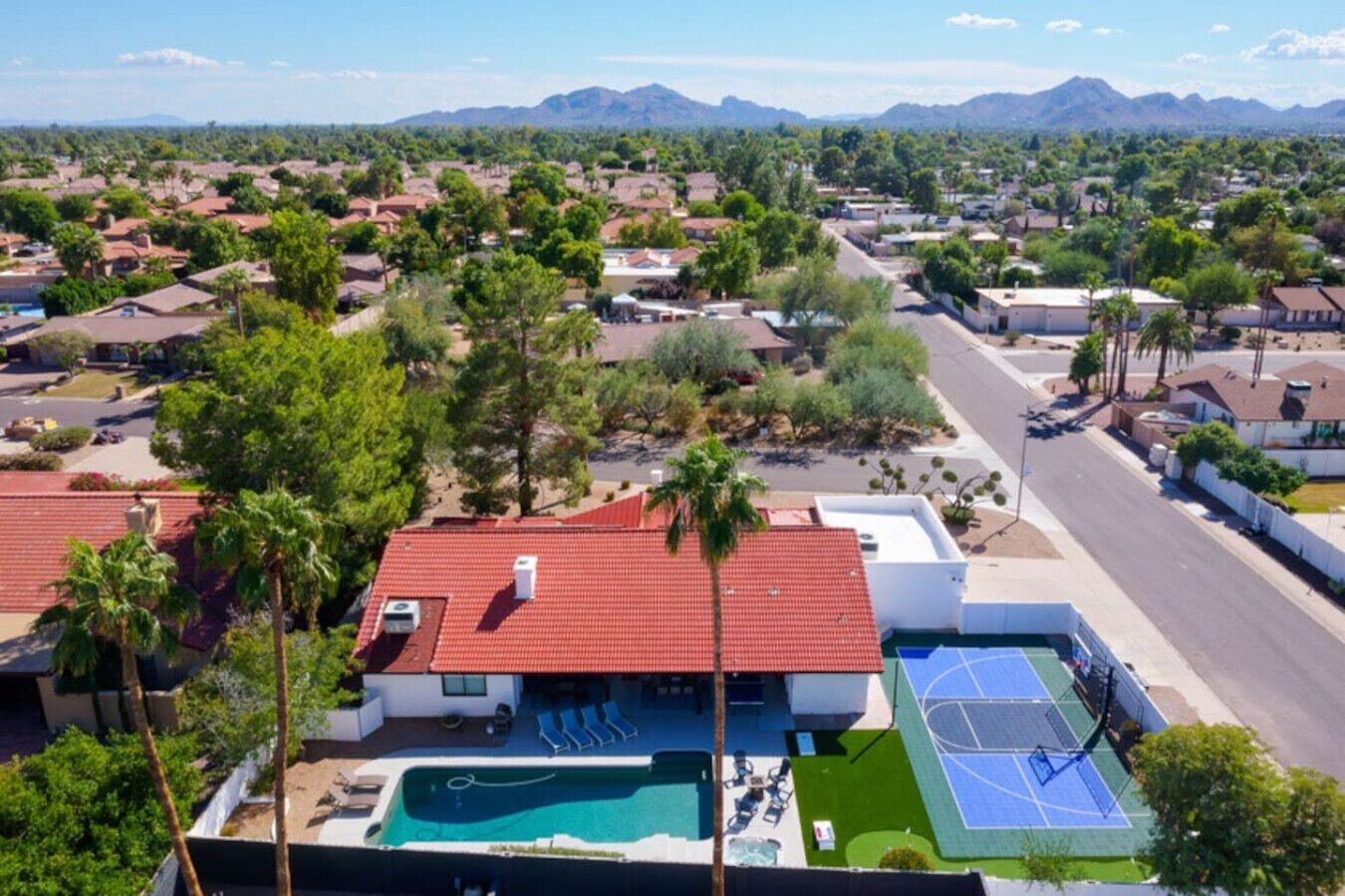A residential area with houses, a swimming pool, and a tennis court.