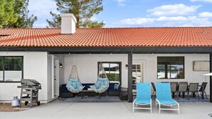 A poolside area with a red-tiled roof, hanging chairs, and a barbecue grill. - Pickleball-Basketball-HeatedPool-Spa-2 Primary BRs (Scottsdale)
