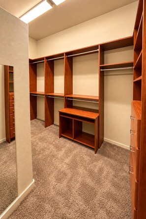 A walk-in closet with multiple shelves and drawers, carpeted floor, and a skylight. - The Gem of The Preserve (Marana)