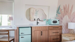 Une cuisine moderne équipée d’un évier, d’un four à micro-ondes et d’un placard.
