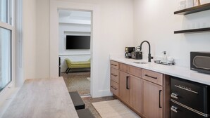 A modern kitchen with a built-in microwave, coffee maker, and a black refrigerator. - Aviles Double Full- 5 min walk to beach! (St. Augustine)