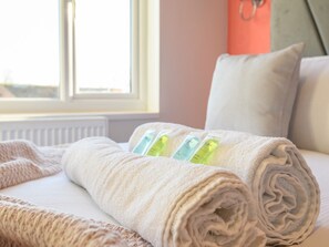 A neatly made bed with a rolled white towel and a set of toiletries. - Lower Wortley 3 - Couples Haven with a Shared Kitchen - Pass the Keys (Leeds)