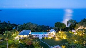 A resort with a swimming pool, multiple buildings, and lush greenery.