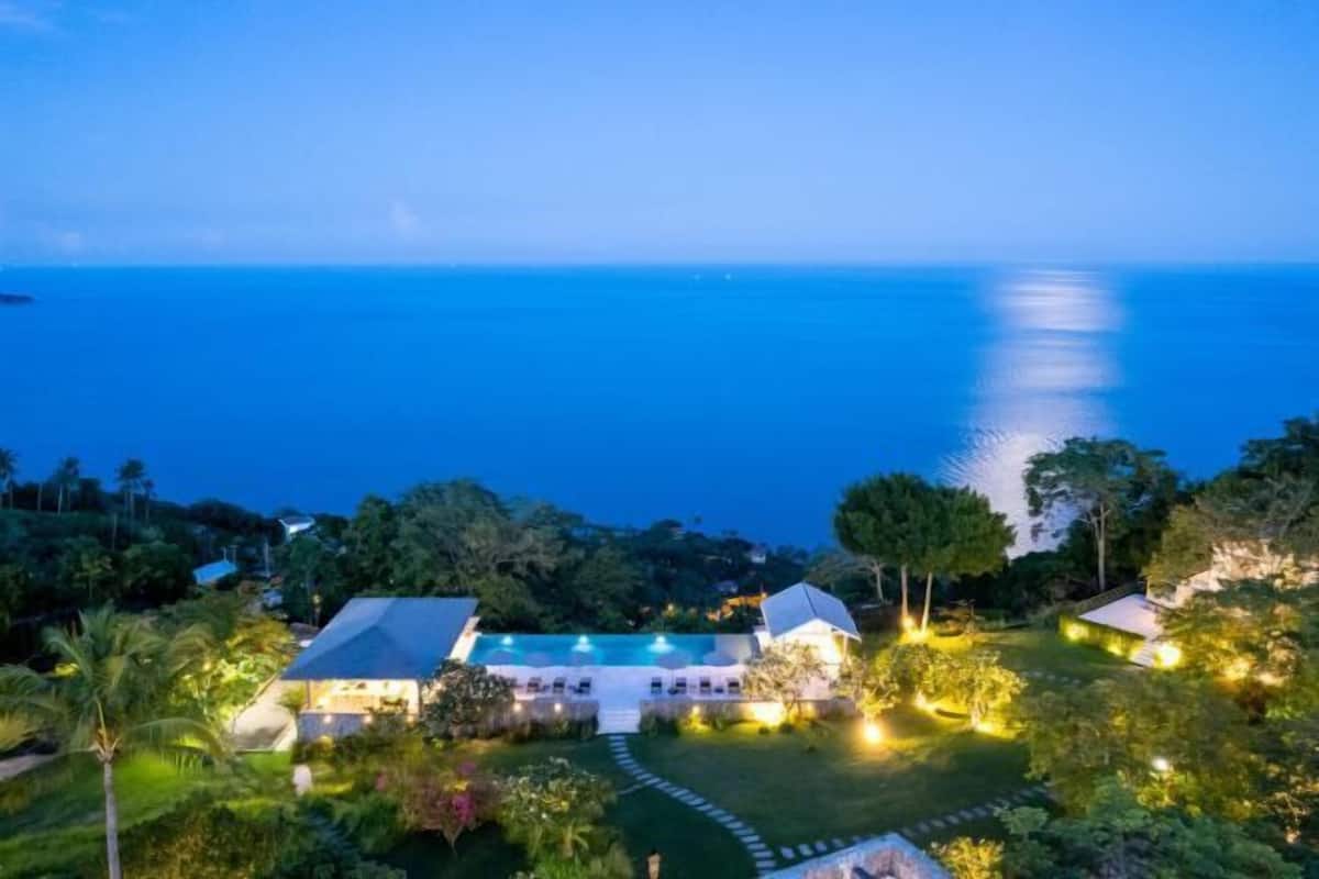 A resort with a swimming pool, multiple buildings, and lush greenery.