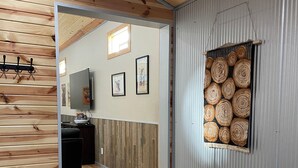 A wooden interior with a staircase leading to a room with a large window and a wall-mounted artwork. - Spacious Convenient Downtown Cody Location (Cody)