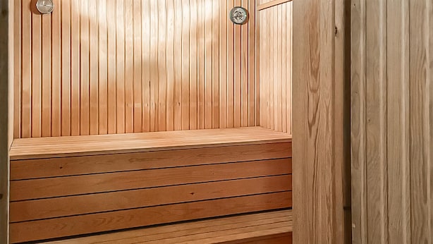 Un banc de sauna en bois, doté d’une conception à lattes et d’une surface supérieure plane.
