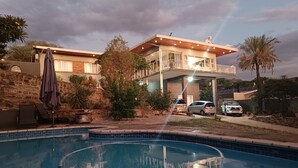 Una casa de dos pisos con una piscina al frente.