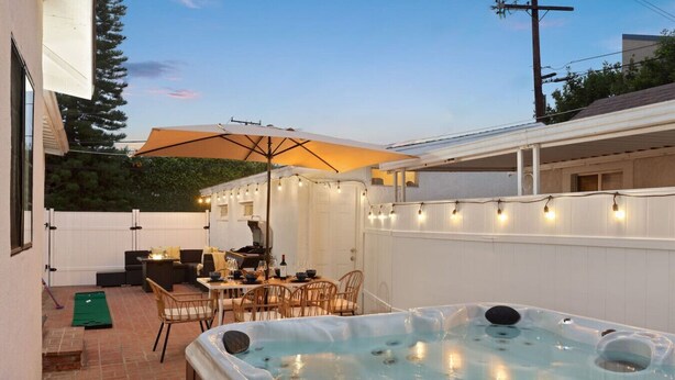 A backyard with a hot tub, outdoor seating, and string lights. - Jacuzzi, Parking, and Game Night Retreat with PS4 PacMan Darts Grill (Culver City)