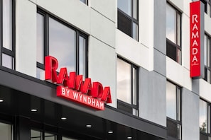 Ein Gebäude mit einem Schild, auf dem 'RAMADA BY WYNDHAM' steht.