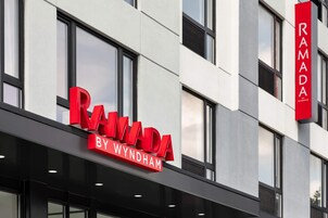 A building with a sign that reads "RAMADA BY WYNDHAM".