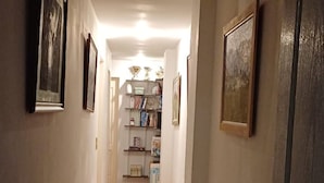 Un couloir étroit, doté d’un plancher en bois et orné de tableaux encadrés accrochés aux murs.