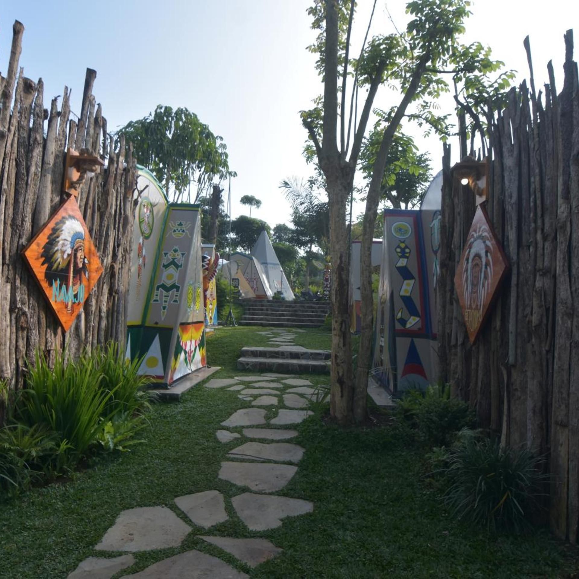 A pathway leading to a building with colorful, geometric designs on the walls.