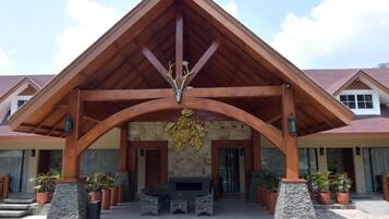 A building with a wooden facade, a stone wall, and a central archway.