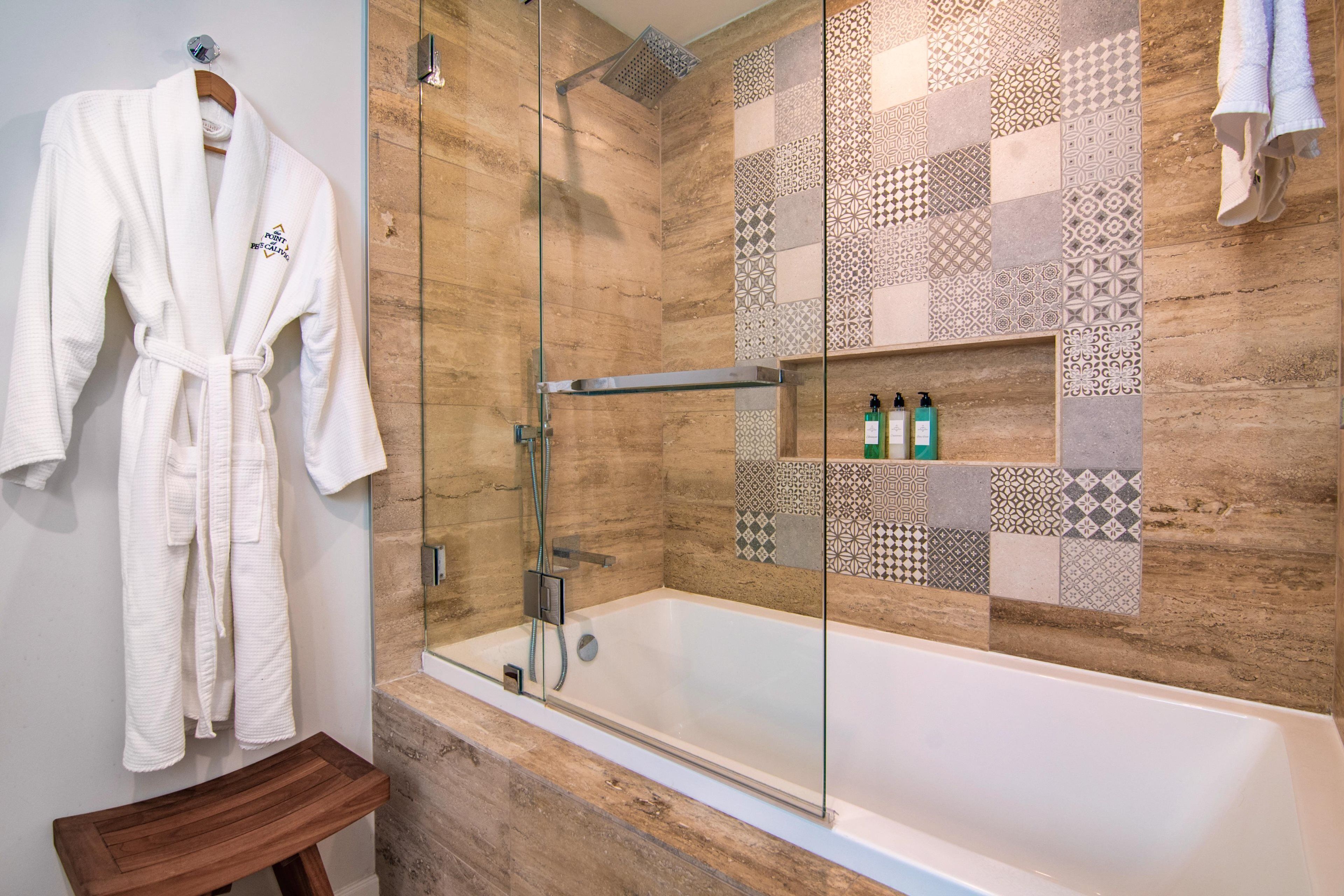 Une salle de bain moderne avec une douche à parois de verre, une baignoire blanche et un banc en bois.