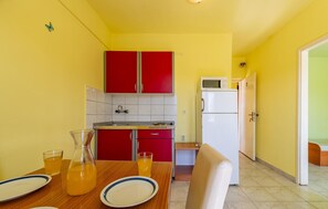 Compact kitchen with a dining table and microwave for meal preparation.