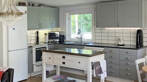 A modern kitchen with white cabinets, a black countertop, and a window providing natural light.
