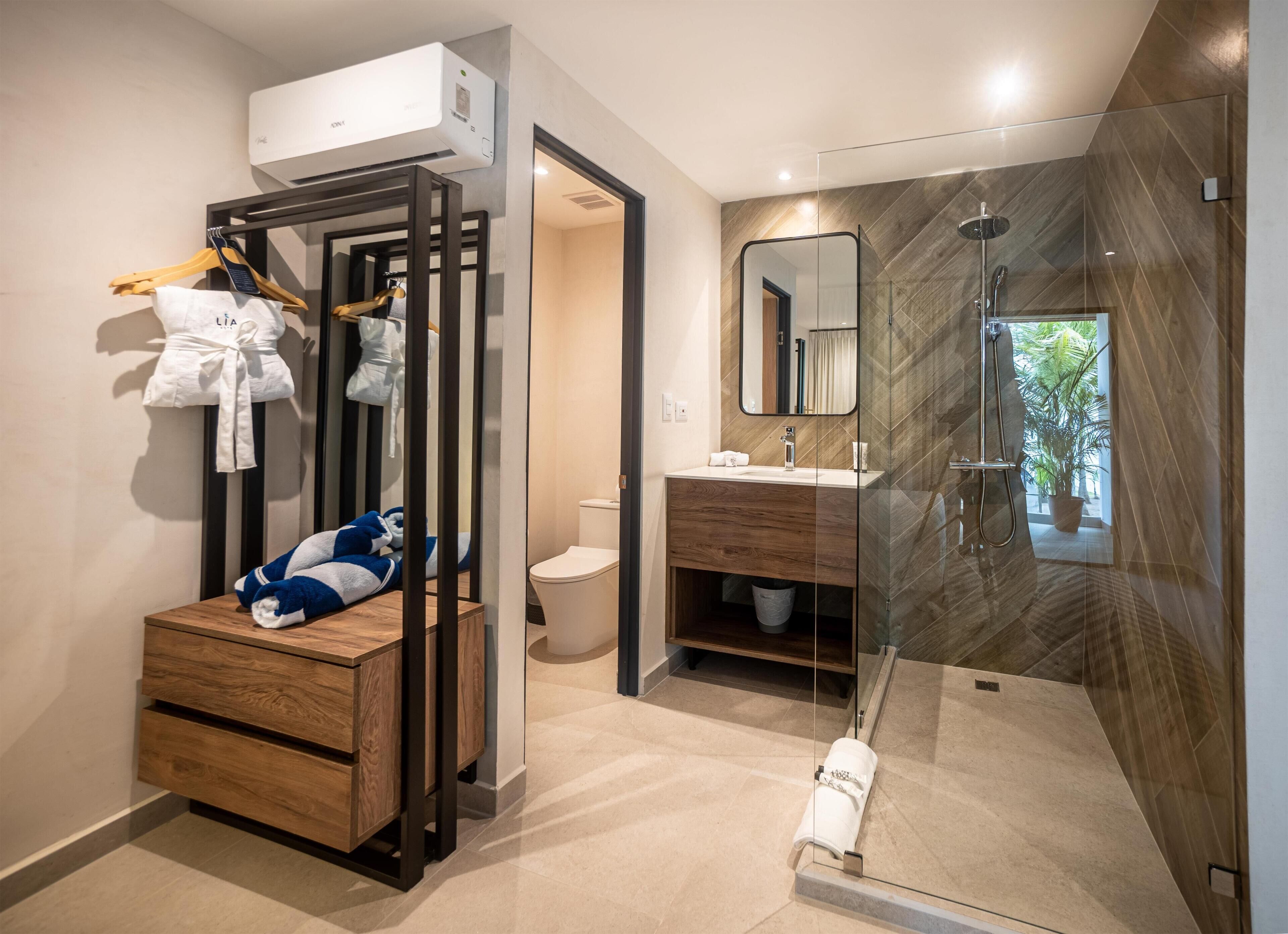 A modern bathroom with a shower, toilet, and a wooden vanity.