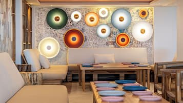 Een modern interieur met een houten tafel, comfortabele zittingen en een wand versierd met ronde lampen.