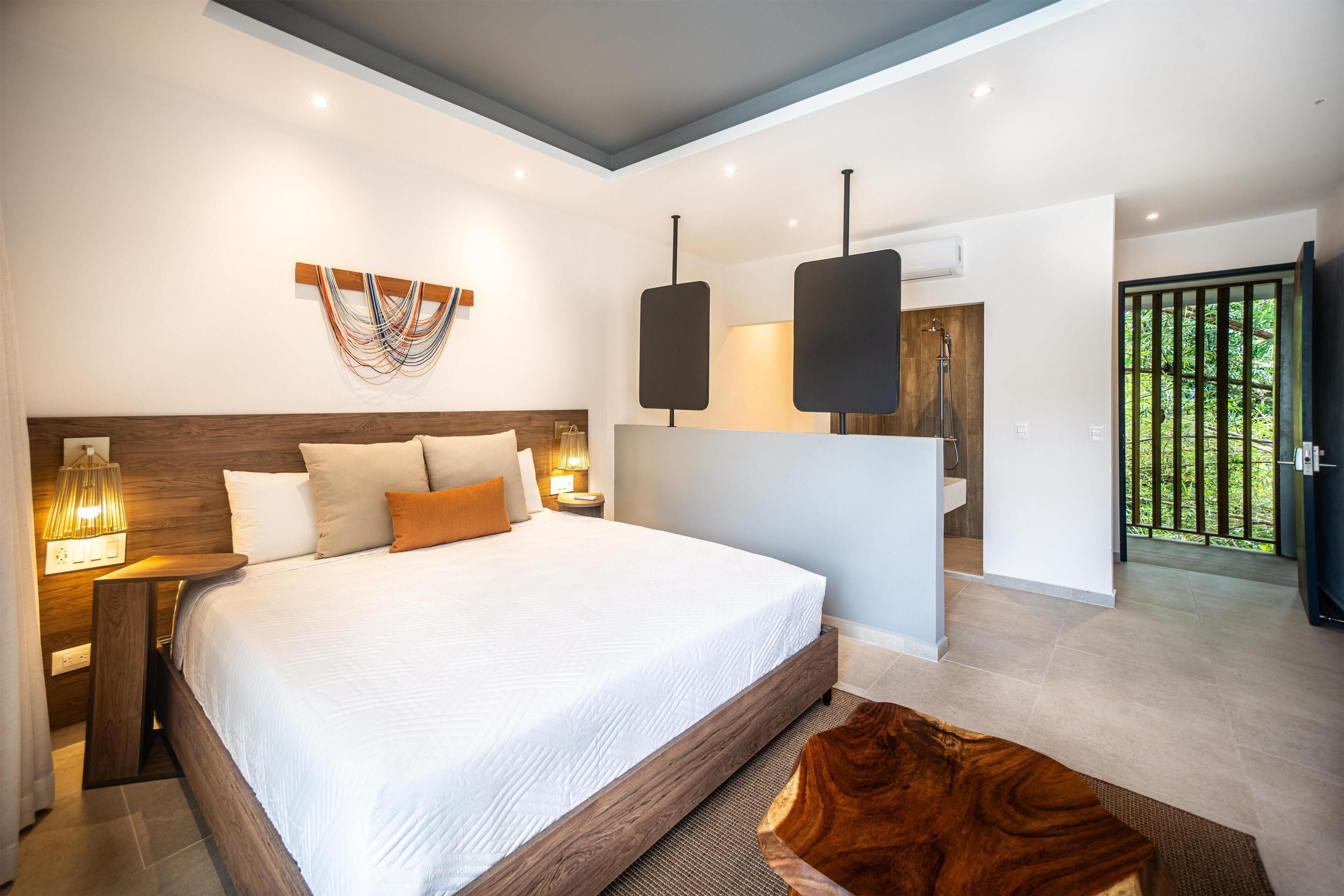 Ein modernes Schlafzimmer mit einem großen Bett, Nachttischlampen, einem Holzkopfseitenverkleidung und Blick ins Freie.