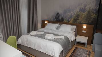 Habitación de hotel moderna con una cama grande, un escritorio y una silla. Hay un cuadro en la pared y una ventana con cortinas.