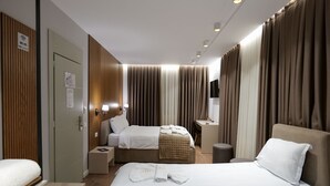 A hotel room with two beds, a desk, and a TV. - Vila Muslli (Korçë)