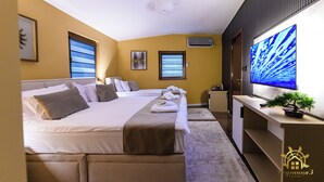 Une chambre d’hôtel avec deux lits, une télévision, un bureau et une plante en pot.