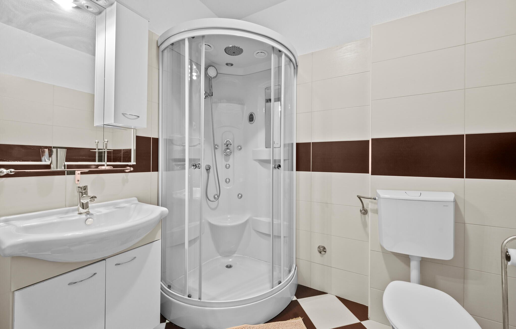 Une salle de bain moderne avec une douche à parois de verre, un lavabo blanc et des toilettes.
