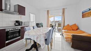 A modern kitchen with a dining area, a sofa, and a view of the city. - Amazing apartment in Vodice with WiFi (Vodice)
