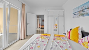 A bedroom with a bed, a nightstand, a chair, a wardrobe, and a sliding glass door leading to a balcony. - Amazing apartment in Vodice with WiFi (Vodice)
