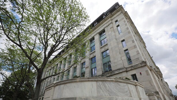 Das äußere Gebäude der Harvard Medical School mit klassizistischer Architektur, das eine markante Eingangspforte und einen großen Baum im Vordergrund zeigt.