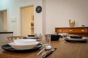 A dining table with plates, bowls, glasses, and cutlery. - Blue Bay Alghero Blue Bay Alghero (Alghero)