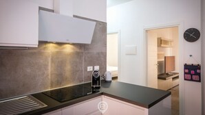 Una cucina moderna con cappa integrata, bollitore e macchina da caffè sul piano di lavoro.
