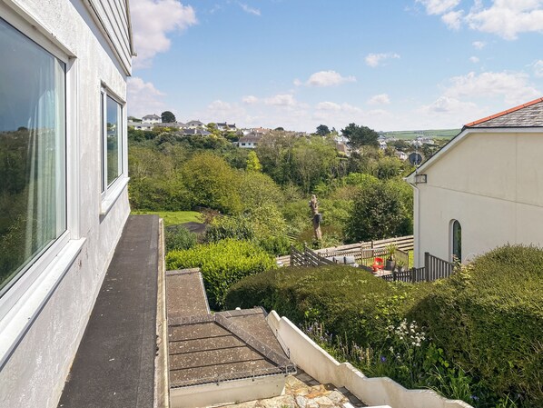 A residential building with a view of a green landscape and distant houses. - 1 bedroom accommodation in St Mawes (St Mawes)