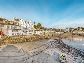 A coastal hotel with multiple stories, a beach in the foreground, and a view of the sea. - 1 bedroom accommodation in St Mawes (St Mawes)
