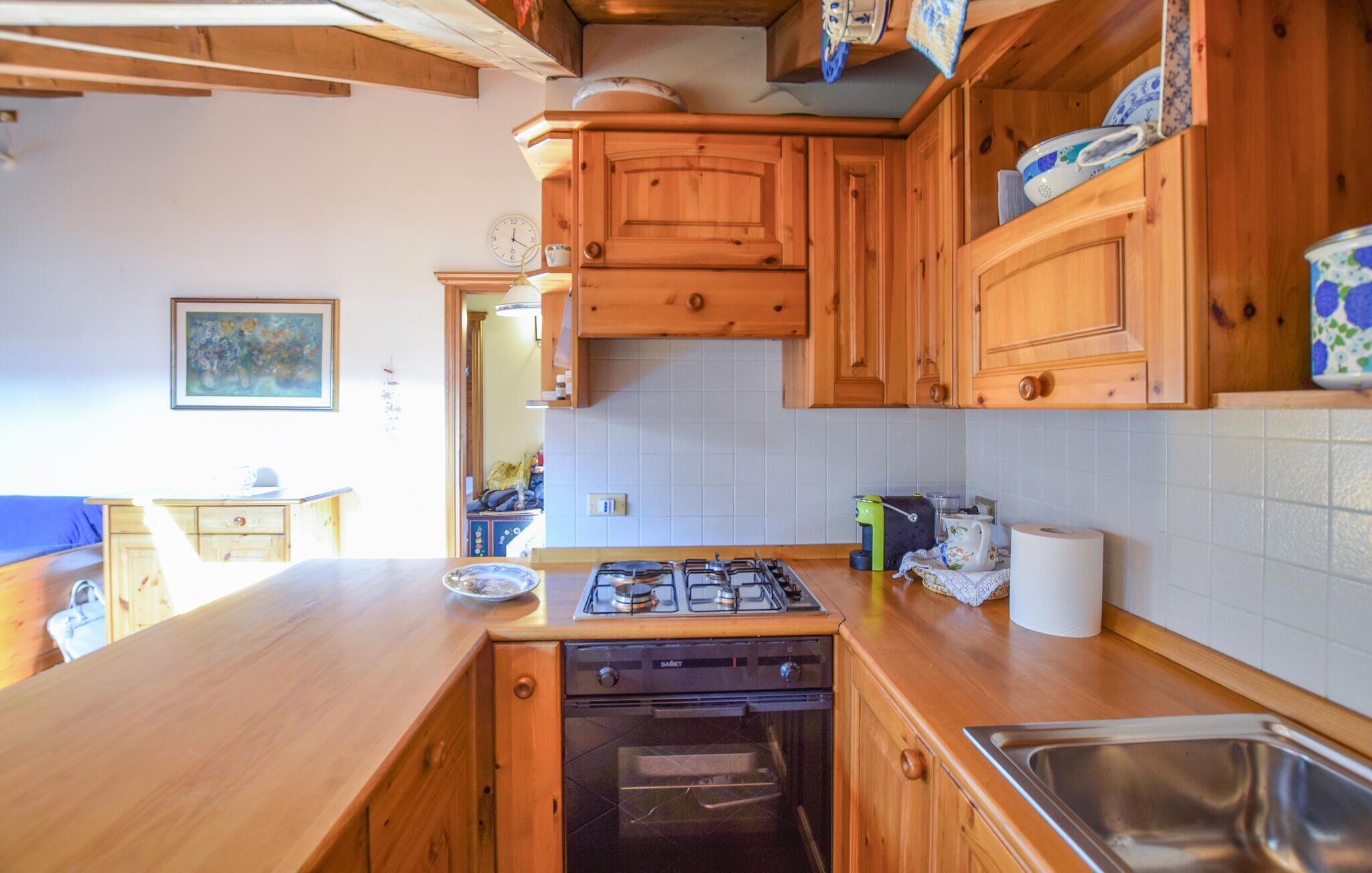 Une cuisine avec des meubles de rangement en bois, une cuisinière à gaz, un four et un évier.