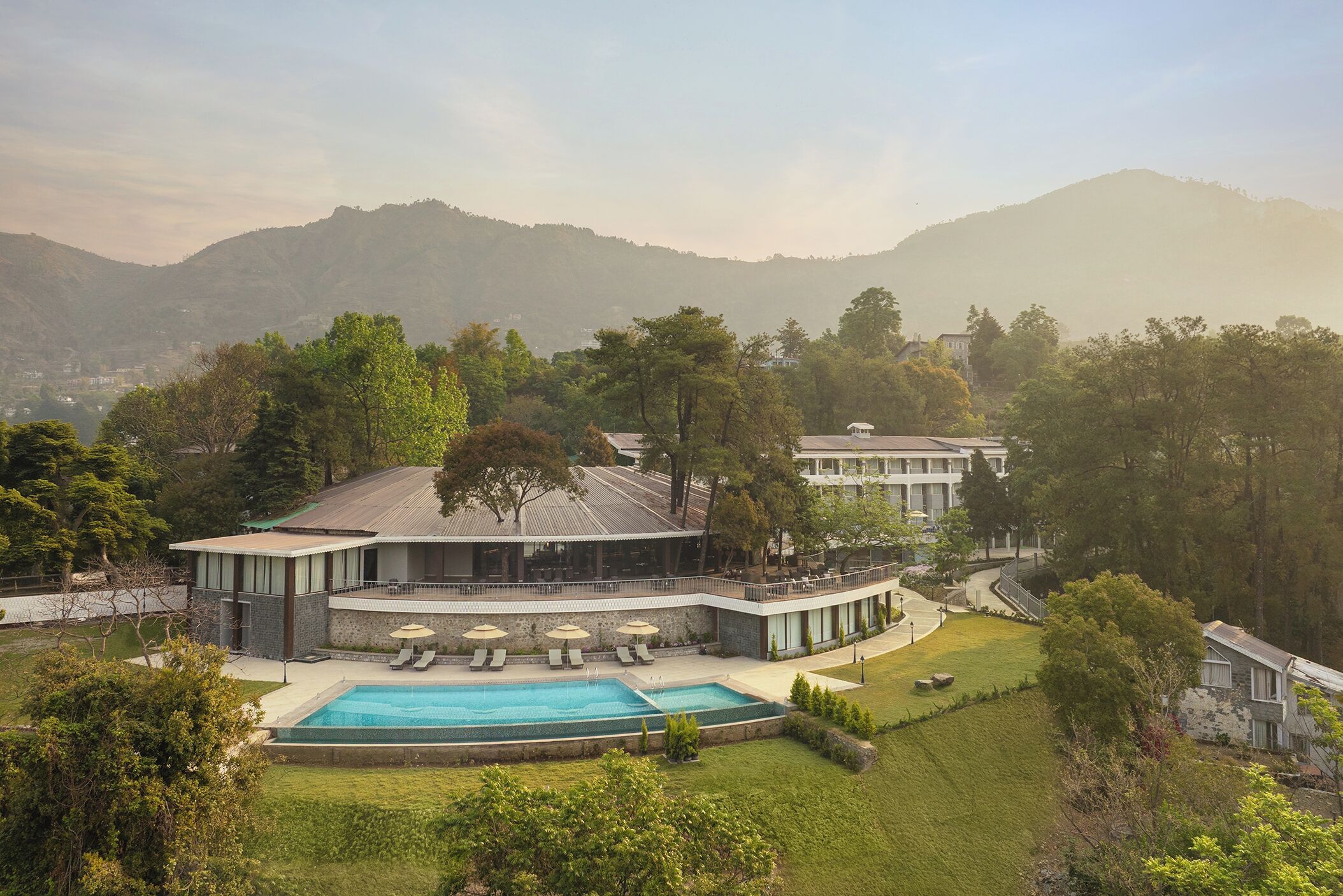 Ein Resort mit Swimmingpool, Liegestühlen und Bergblick.