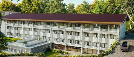 Un hotel de varios pisos con techo plano, ventanas amplias y un patio central con mobiliario.