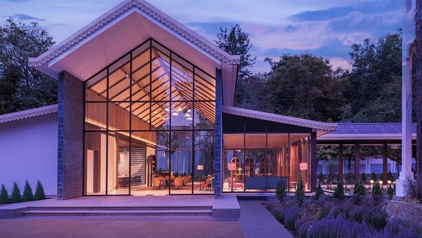 A modern building with large glass windows, a covered patio, and a landscaped garden. - Naukuchia House, Naukuchiatal - IHCL SeleQtions (Nainital)