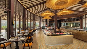 A restaurant with a long counter, multiple hanging lamps, and a buffet area. - Naukuchia House, Naukuchiatal - IHCL SeleQtions (Nainital)