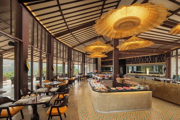 A restaurant with a long counter, multiple hanging lamps, and a buffet area.