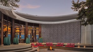 A modern outdoor seating area with steps leading to a fire pit, surrounded by cushioned seating and ambient lighting. - Naukuchia House, Naukuchiatal - IHCL SeleQtions (Nainital)