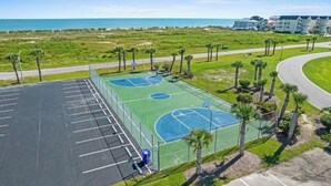 Una cancha de baloncesto al aire libre con vista al océano y la playa.